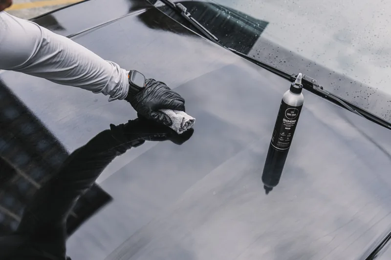 Diamond AI being applied by hand to a painted bonnet.